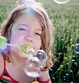 Girl blowing bubbles to camera